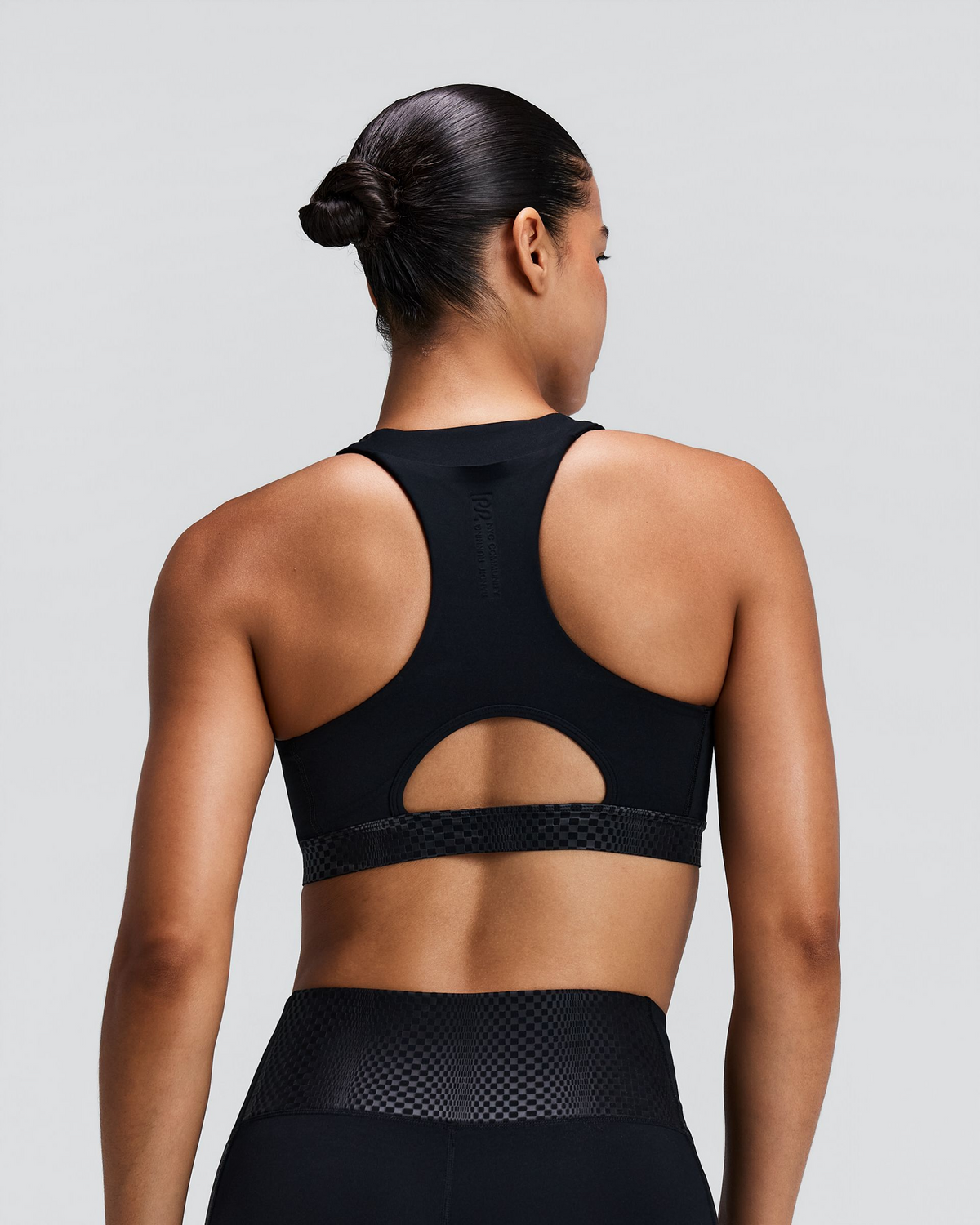 Top deportivo Bandit Stamina-V Threshold para mujer, color negro - vista posterior en modelo