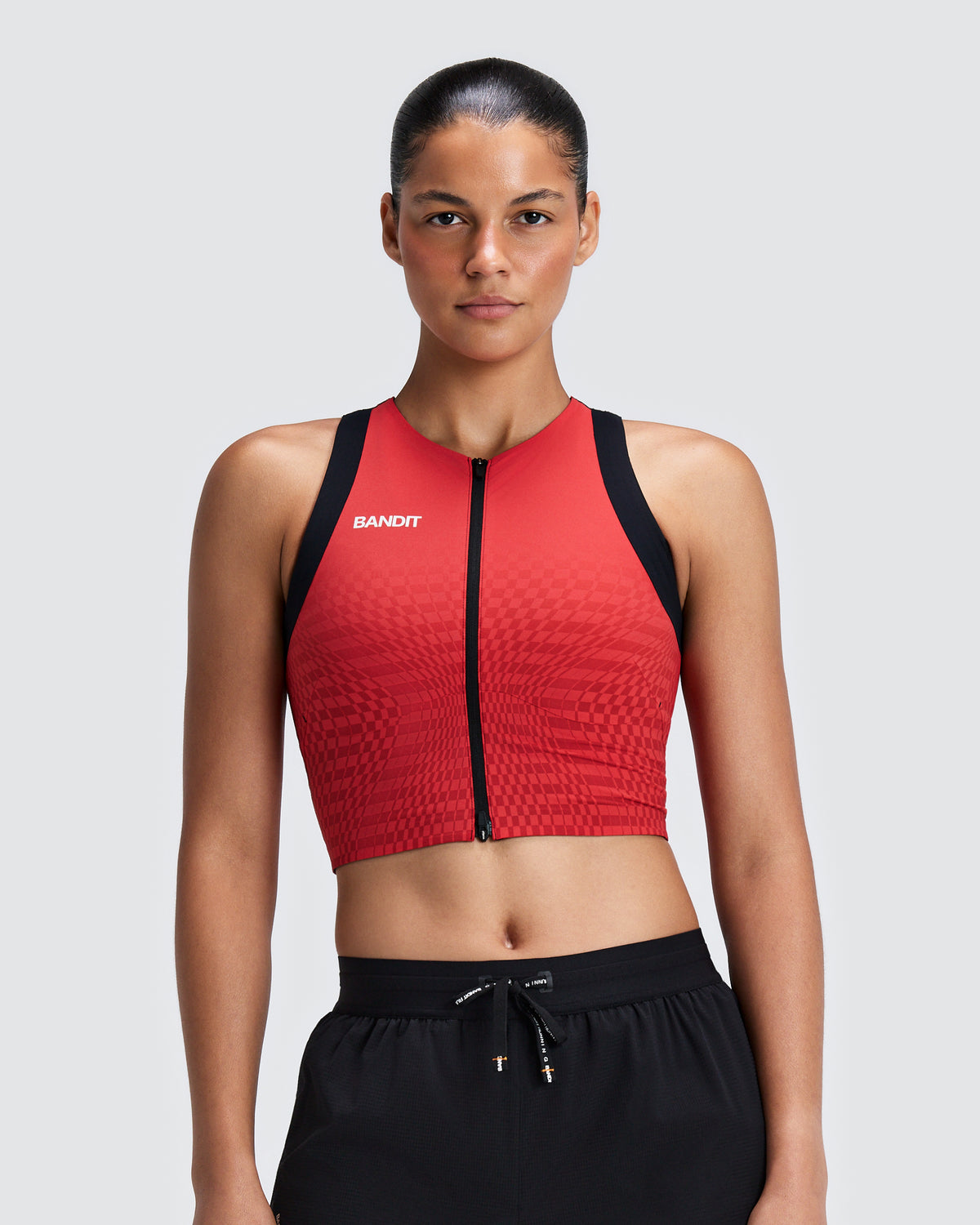 Top de competencia Bandit Adapto para mujer, color Oxide Red - vista frontal en modelo