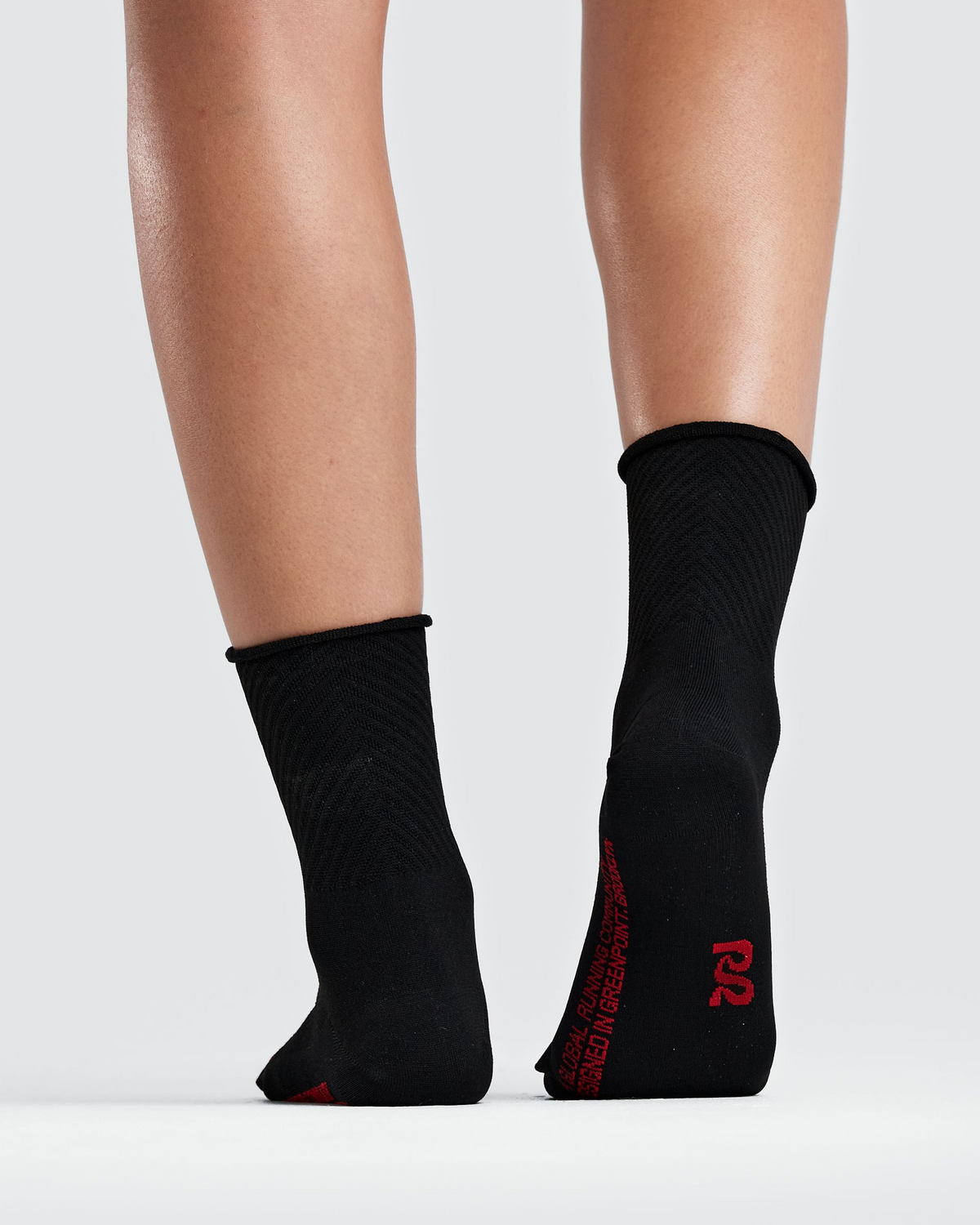 Medias de running Bandit Lite Run Ribbed, color negro con Oxide Red - vista posterior en modelo
