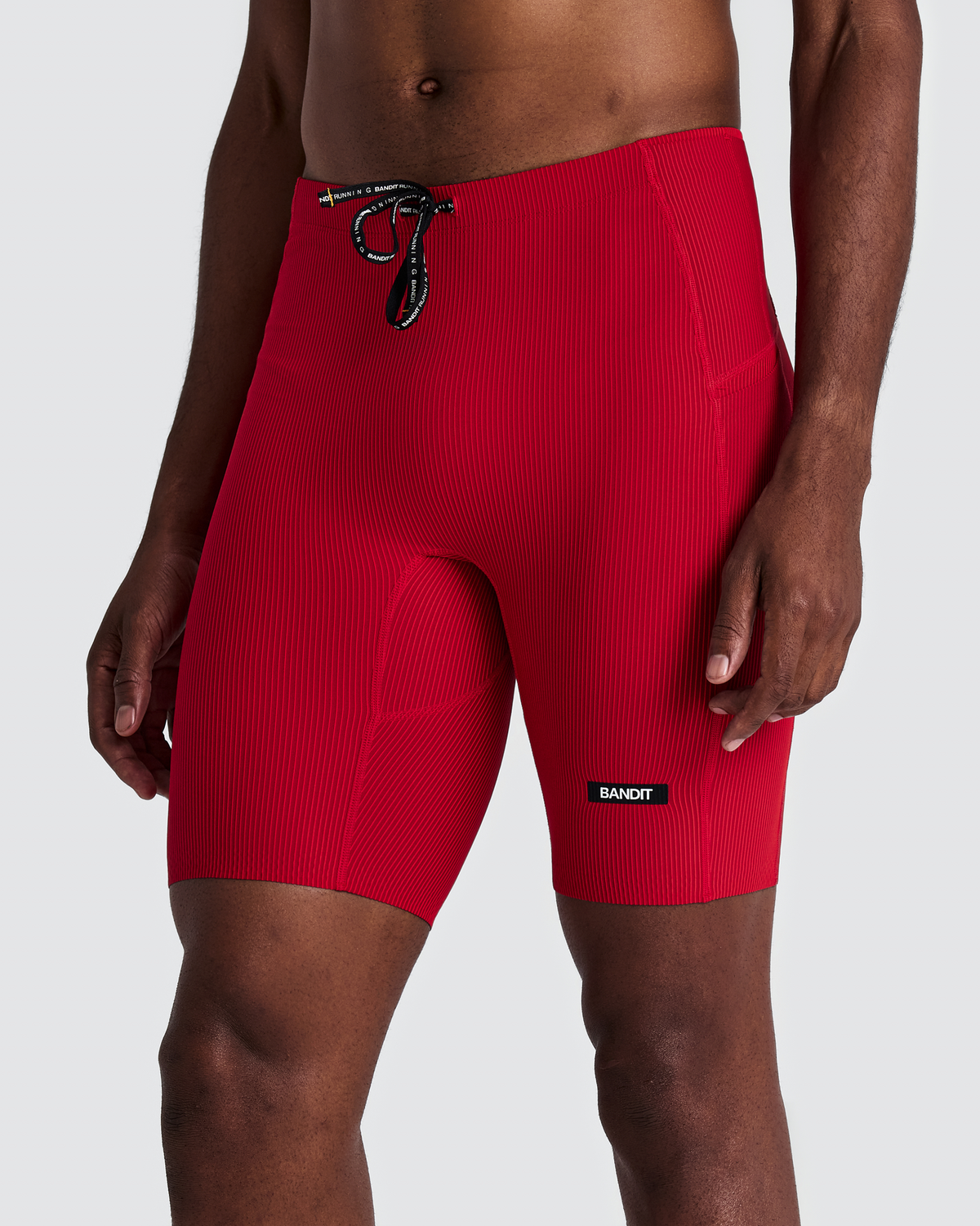 Malla corta Bandit Cadence 7 Pocket para hombre, color Striped Oxide Red / Signal Red - vista frontal en modelo