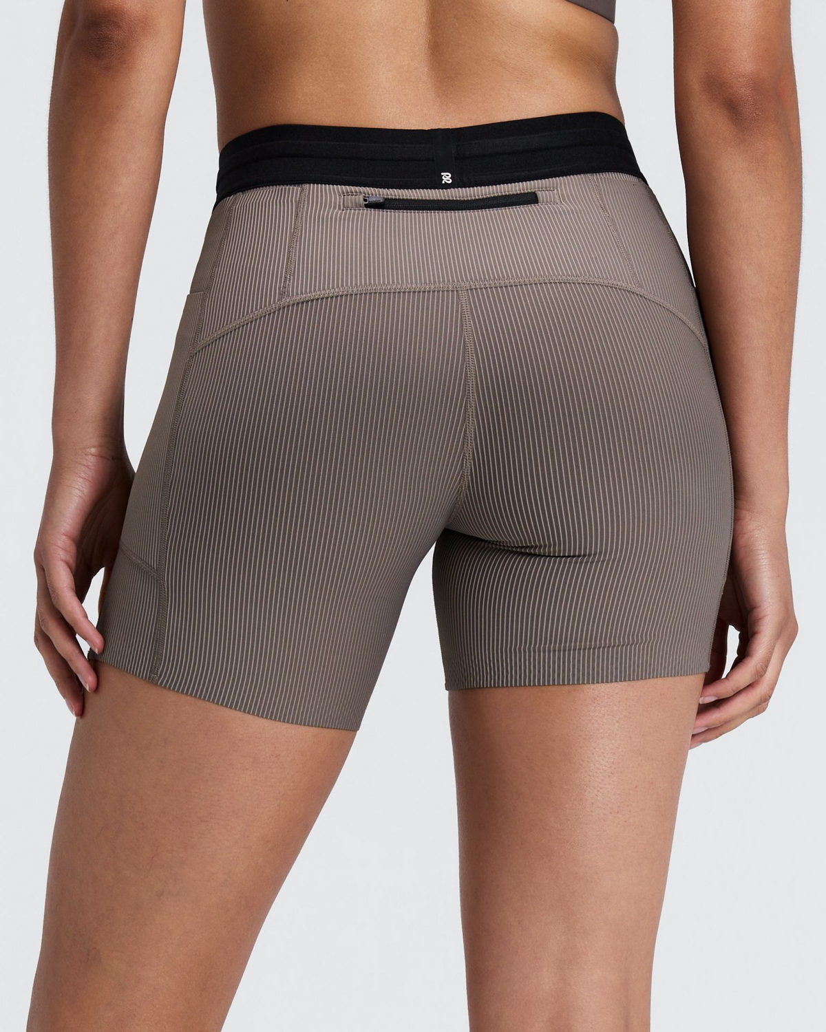 Women's Cadence Comp. Shorts Concrete Taupe / Cocoa - vista posterior en modelo